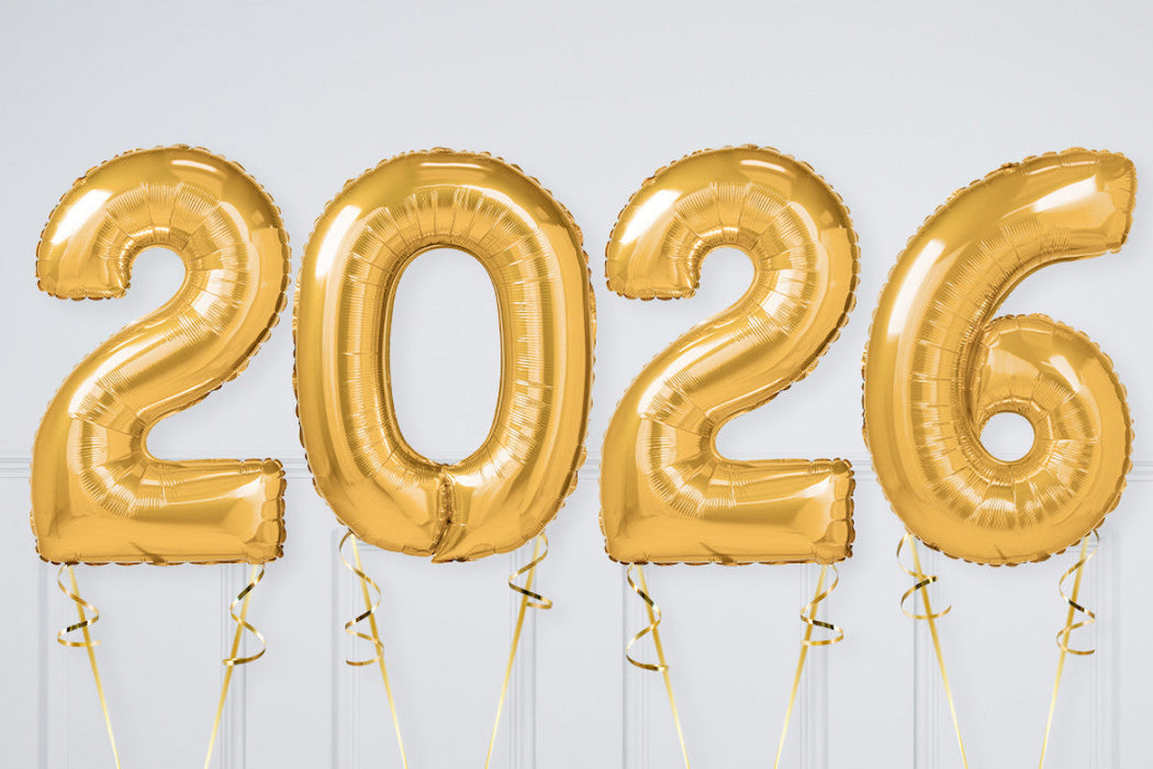 Gold '2026' balloons against a white wall