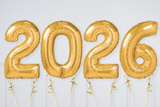 Gold '2026' balloons against a white wall